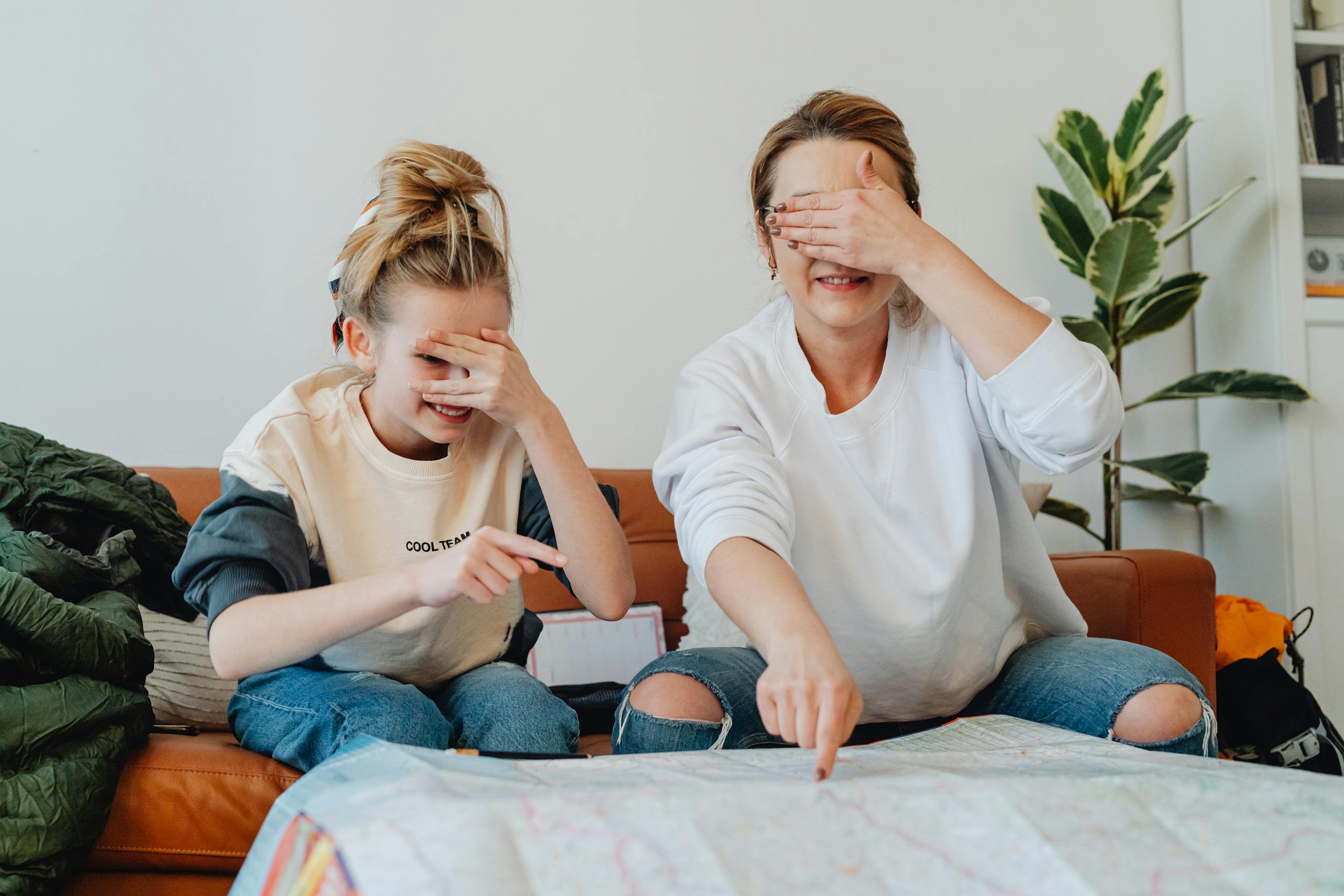 Where to Go... by Adventure Type A mother and daughter planning a fun trip at home, pointing at a map
