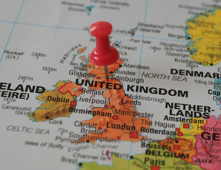 Close-up of a European map highlighting the UK with a red pin, perfect for geography themes.